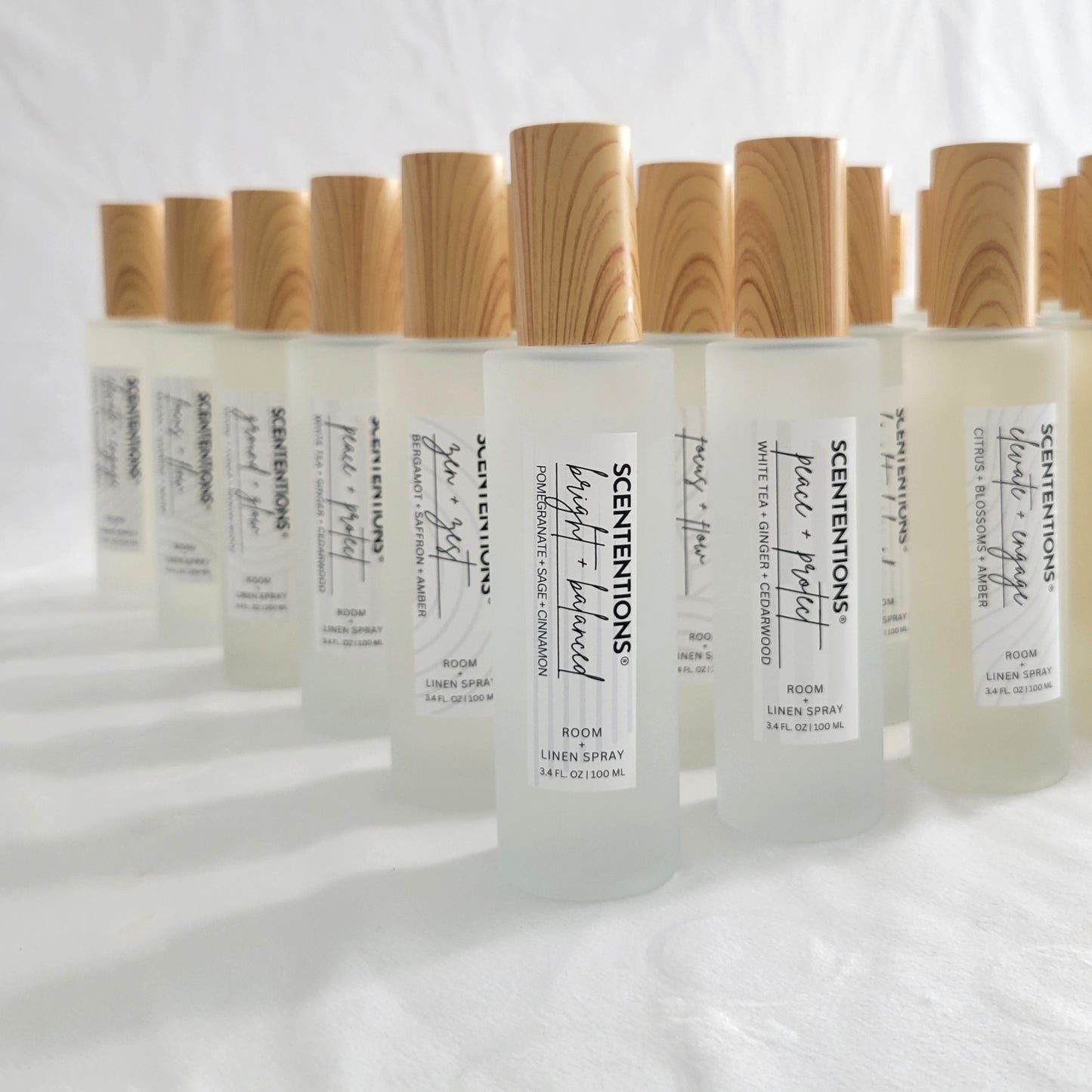 Styled display of the full room and linen spray collection in frosted glass bottles.