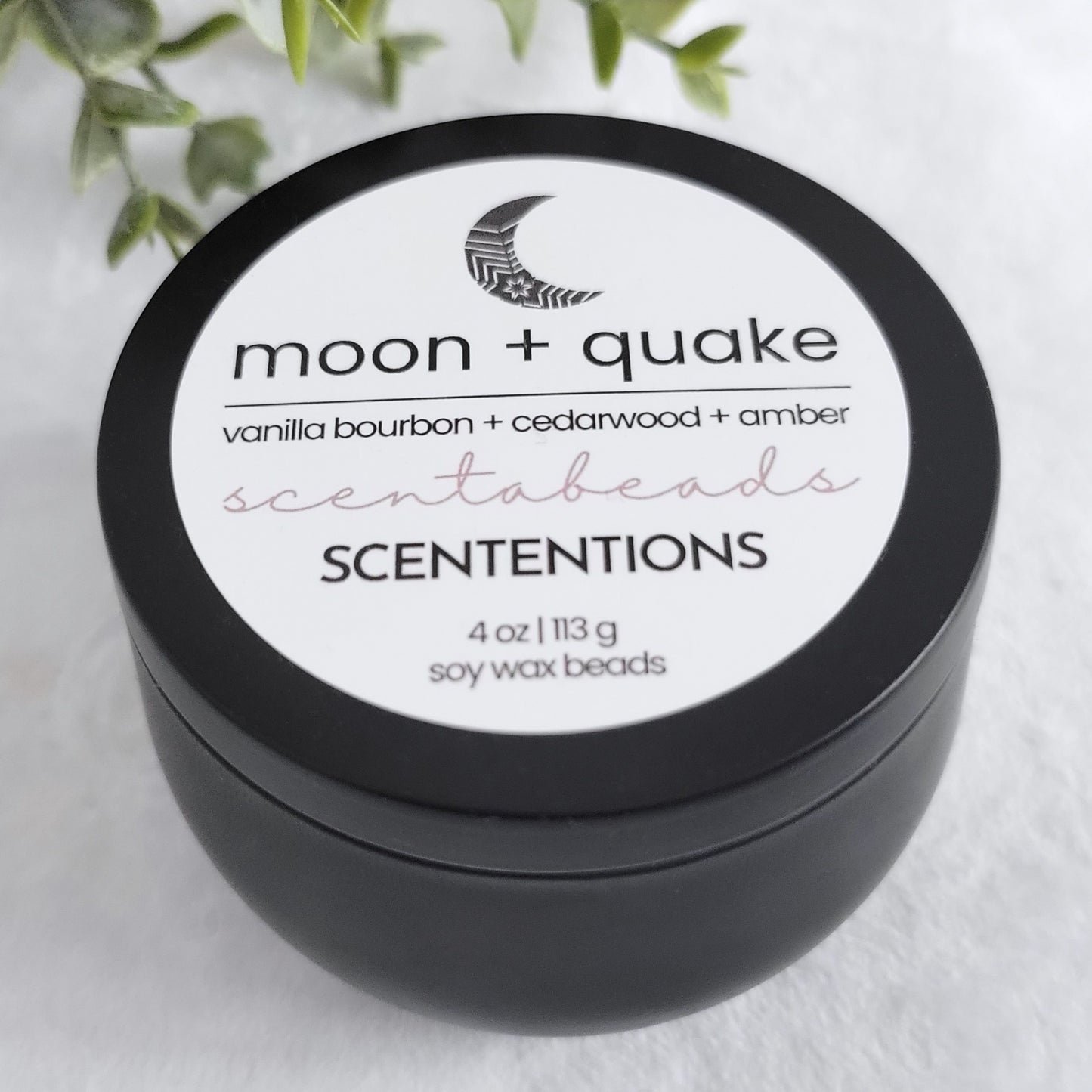 Moon + Quake soy wax melt beads in black tin with Vanilla Bourbon, Cedarwood, and Amber for emotional healing and balance
