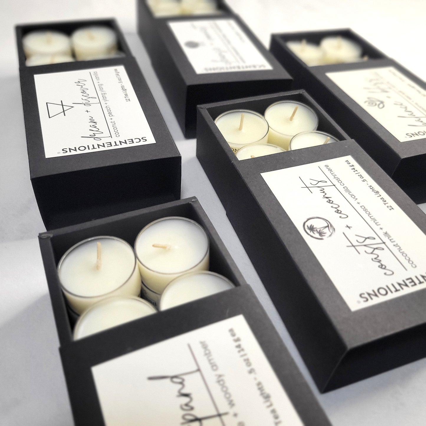 Collection of boxed tea light sets featuring coconut wax candles in various intentional scents by Scententions