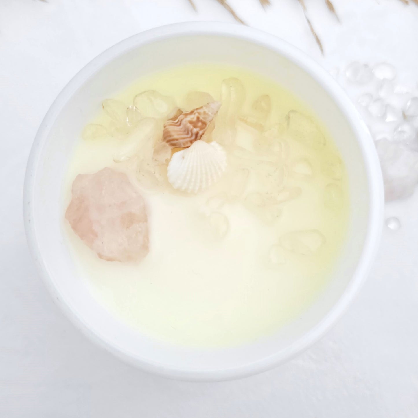 Top view of Coasts + Coconuts candle showing embedded Rose Quartz and Clear Quartz crystals in clean-burning organic coconut wax
