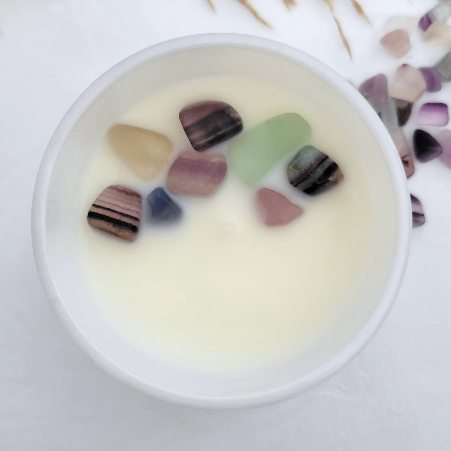Top view of Dream + Discover candle with embedded Fluorite crystals in coconut wax, showcasing clean burn and vibrant gemstone energy