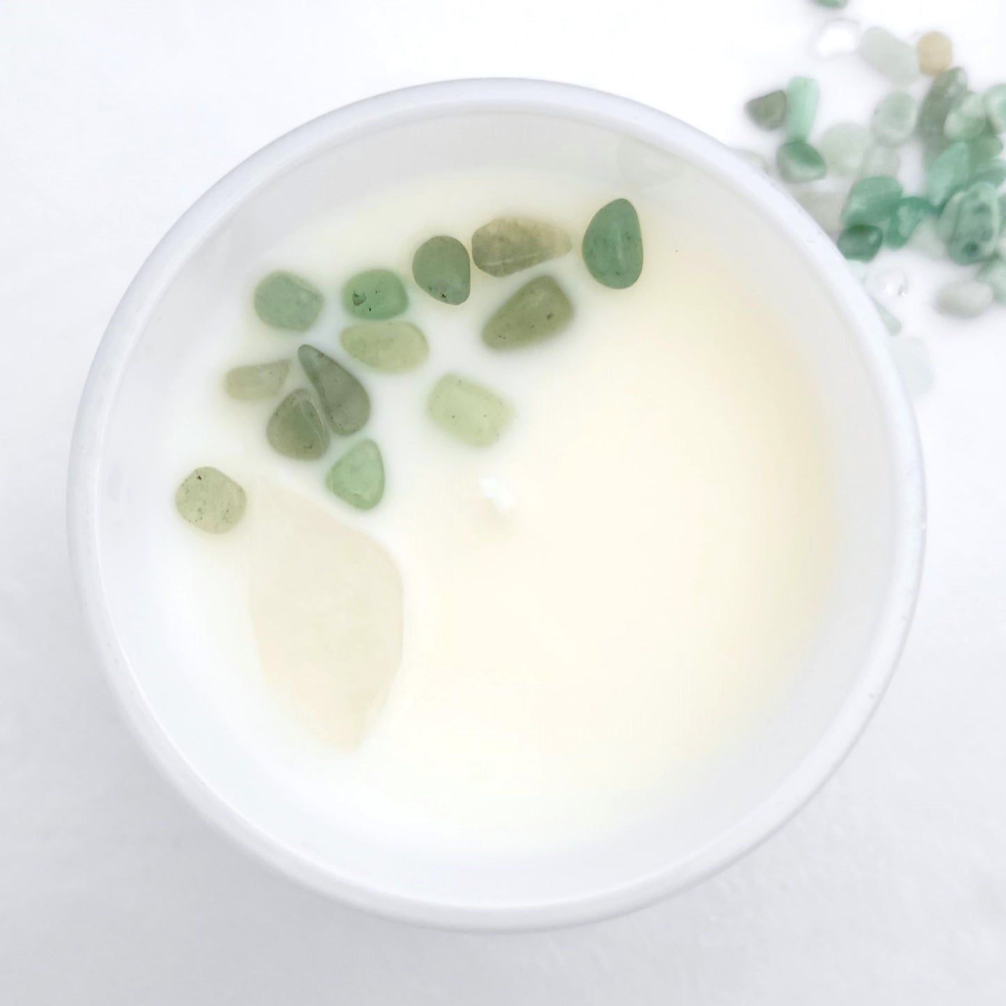 Top view of Explore + Expand candle showing embedded Clear Quartz and Green Aventurine crystals in clean-burning organic coconut wax
