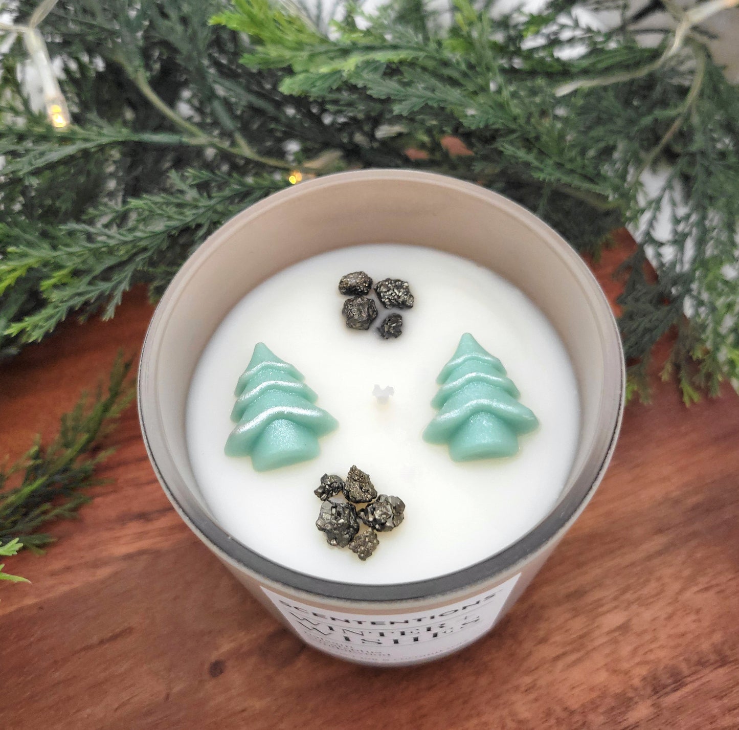 Overhead view of Winter + Wishes holiday candle showing Christmas tree wax embeds and pyrite crystals in coconut wax.
