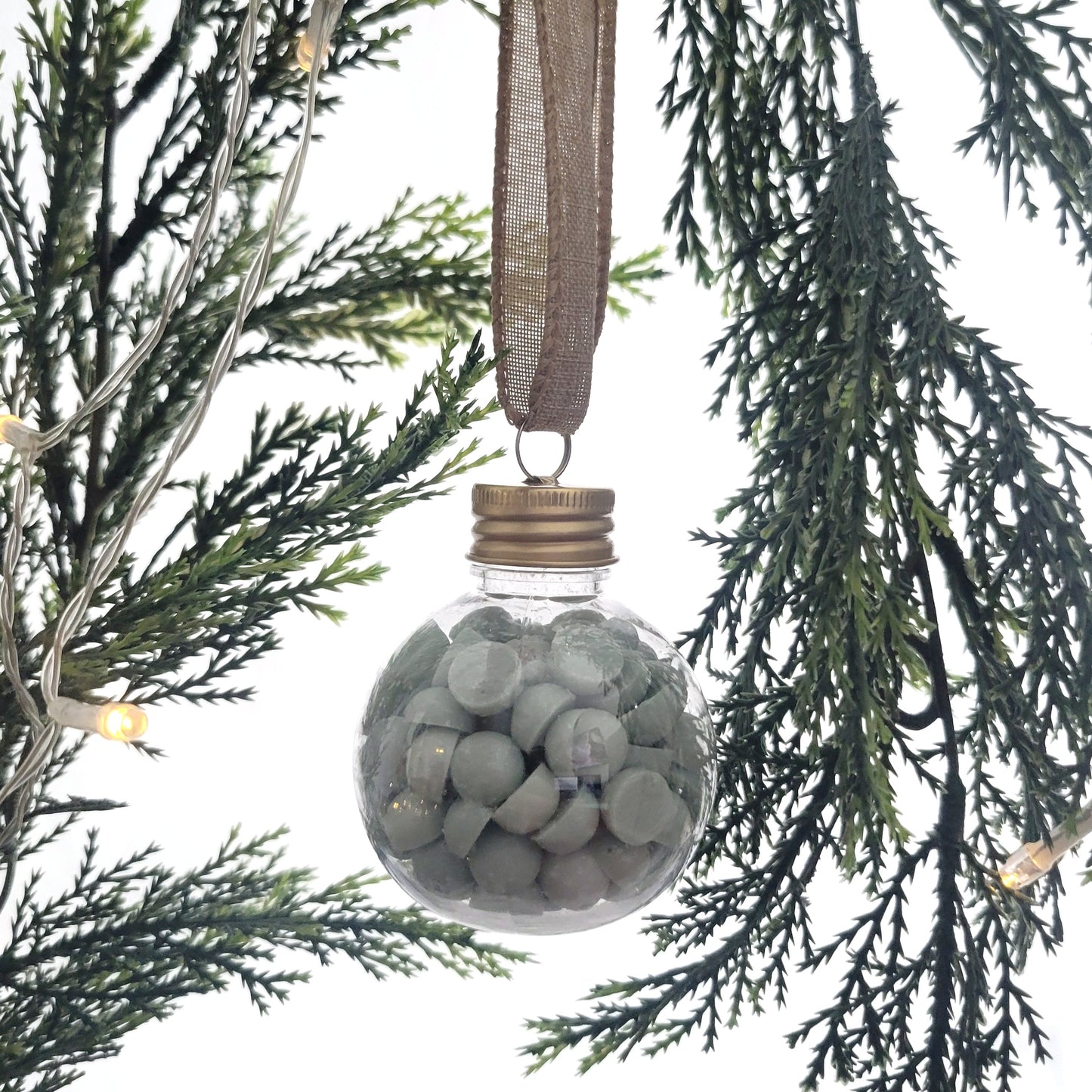 Winter + Wishes ornament filled with 2 oz of beaded coconut wax melts, hanging on a Christmas tree as a festive holiday decoration.
