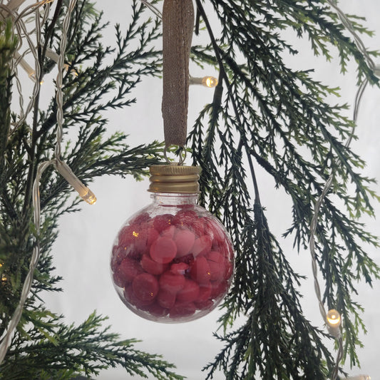 Berry + Bright ornament filled with 2 oz of beaded coconut wax melts, hanging on a Christmas tree as a festive holiday decoration.