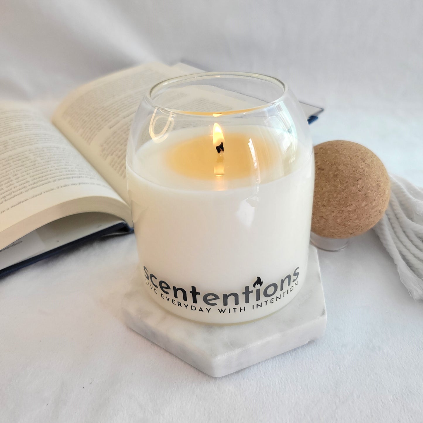 Lit candle with book background – clean and calming ambiance from Scententions
