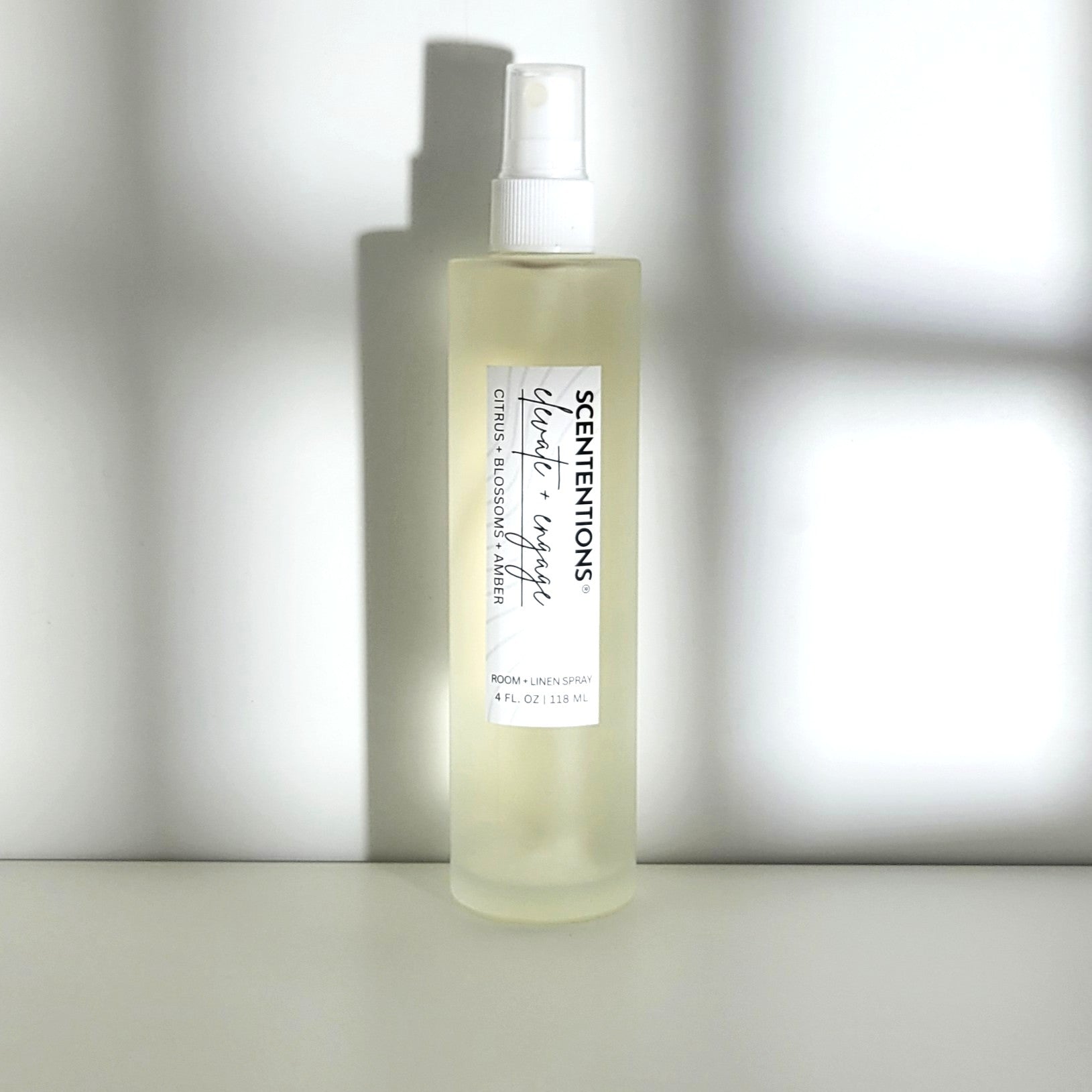Elevate + Engage room spray with citrus, blossom, and amber notes, designed for uplifting energy in modern setting