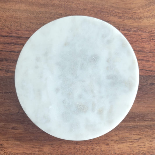 Close-up of round marble candle coaster made from white stone