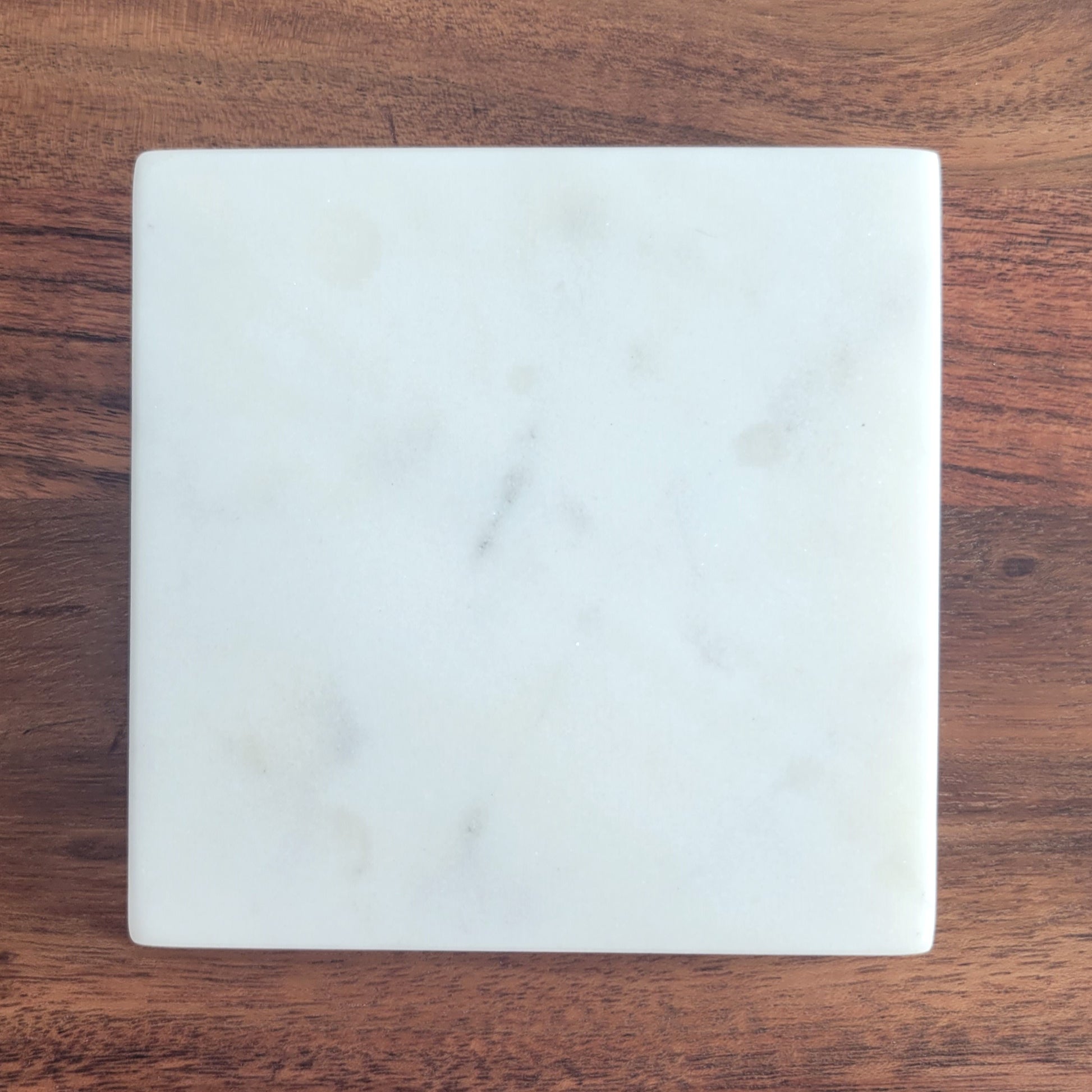 Close-up of smooth square marble candle coaster made from white stone
