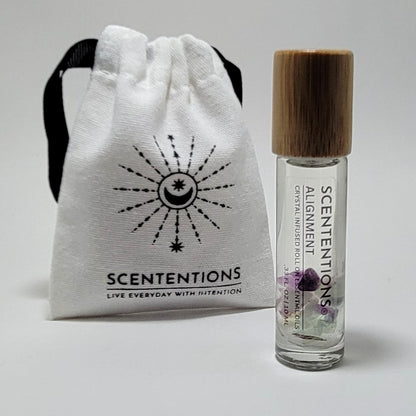 Crystal infused roll-on essential oil with Fluorite crystals next to Scententions canvas pouch
