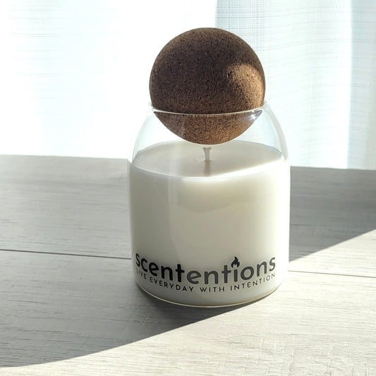 Balance + Bliss signature coconut wax candle in clear glass vessel with cork lid, featuring fresh linen and sandalwood notes.