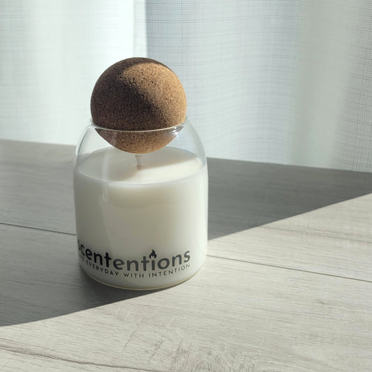 Cleanse + Connect signature coconut wax candle in clear glass vessel with cork lid, featuring orange blossom and sandalwood notes.