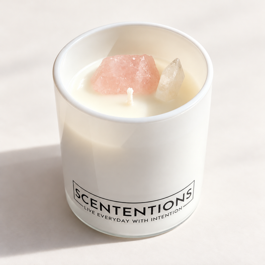 SCENTENTIONS Coasts + Coconuts 7 oz coconut wax candle in white glass vessel with rose quartz and clear quartz crystals.