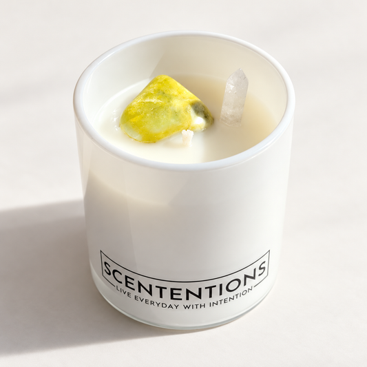 SCENTENTIONS Dream + Discover 7 oz coconut wax candle in white glass vessel with noble serpentine and clear quartz crystals.