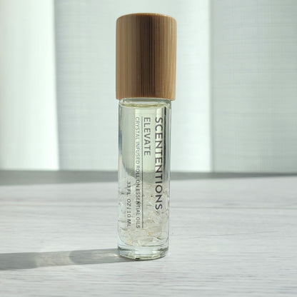 Crystal infused roll-on essential oil with Clear Quartz crystals and bamboo lid on white wood surface in natural light