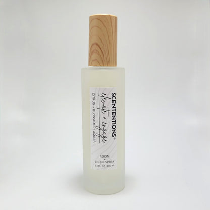Elevate + Engage room and linen spray in frosted glass bottle with wood cap on white background.