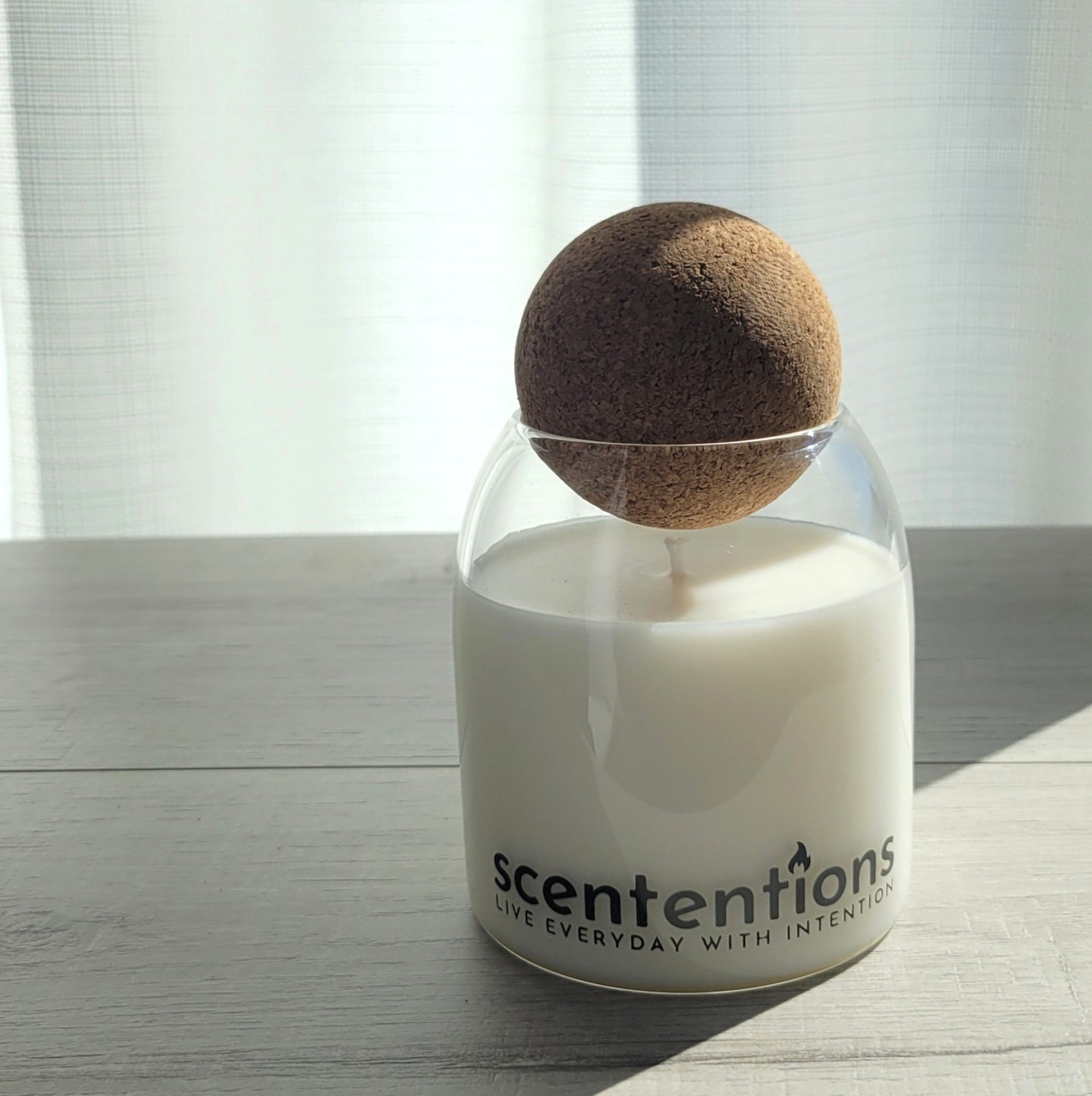 Mindful + Meditation signature coconut wax candle in clear glass vessel with cork lid, featuring amber and frankincense notes.