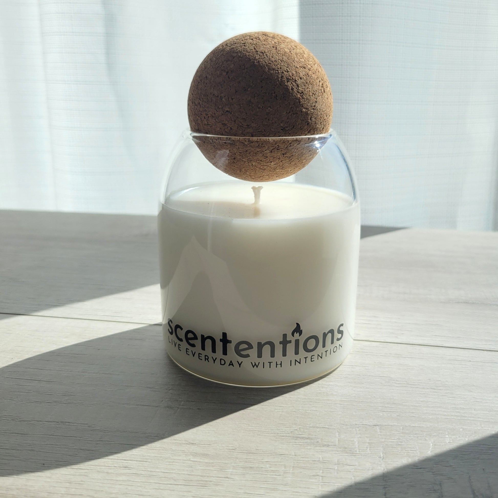Sunshine + Serenity signature coconut wax candle in clear glass vessel with cork lid, featuring tangerine and vanilla notes.