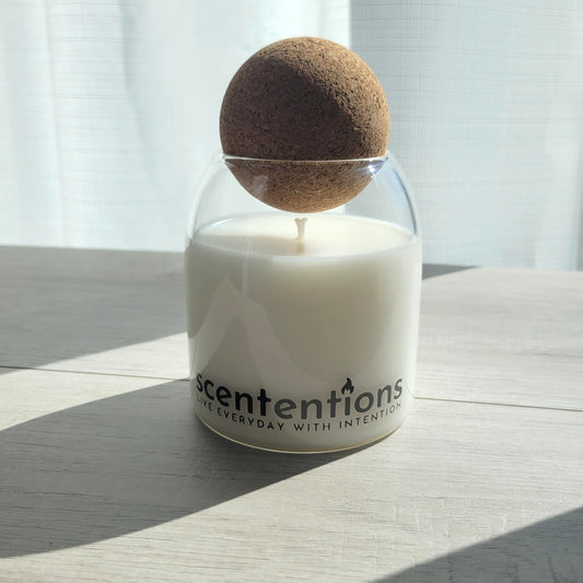 Sunshine + Serenity signature coconut wax candle in clear glass vessel with cork lid, featuring tangerine and vanilla notes.
