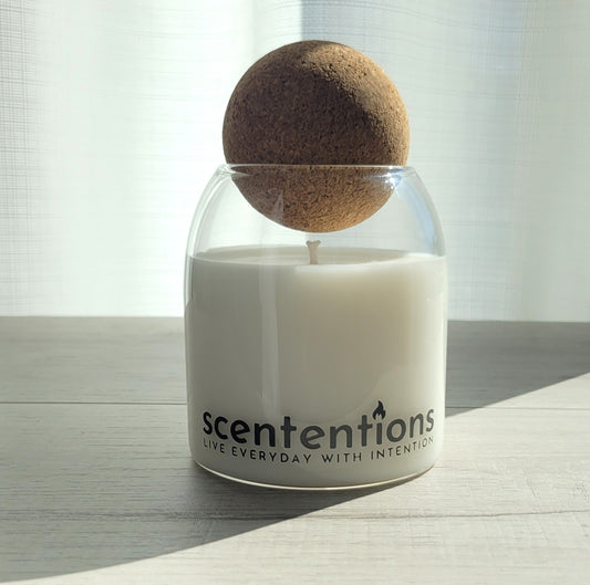 Wander + Wonder signature coconut wax candle in clear glass vessel with cork lid, featuring fig and sandalwood notes.