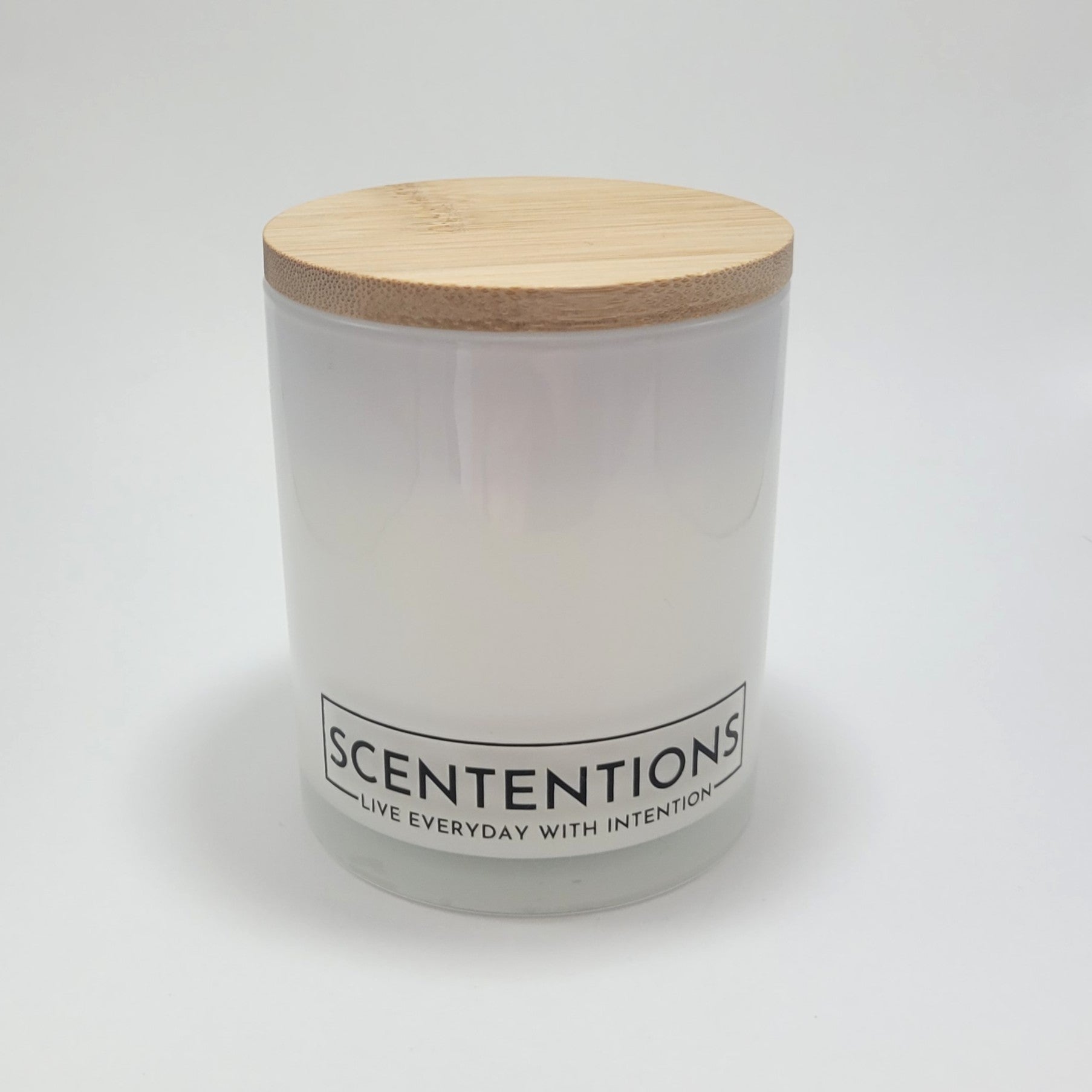 Wanderlust crystal coconut wax candle in clear glass vessel with bamboo lid on white background.