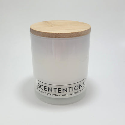 Wanderlust crystal coconut wax candle in clear glass vessel with bamboo lid on white background.
