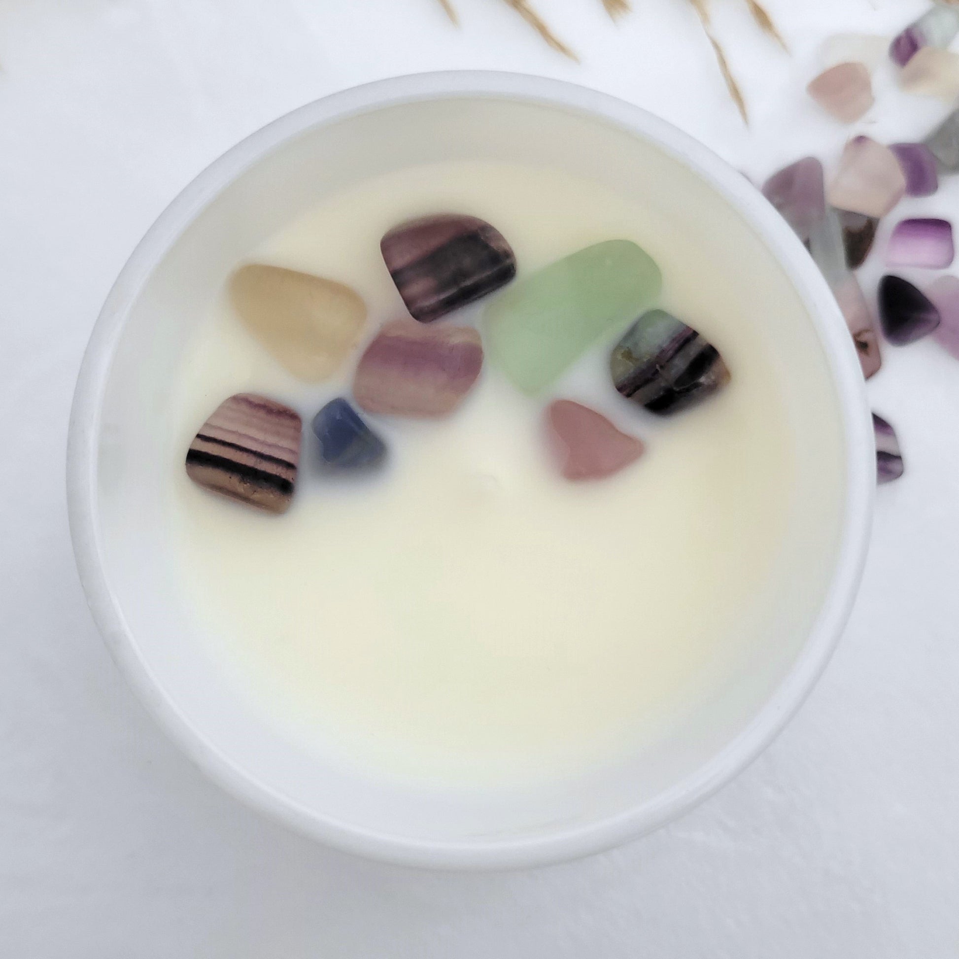 Top view of Dream + Discover candle with embedded Fluorite crystals in coconut wax, showcasing clean burn and vibrant gemstone energy