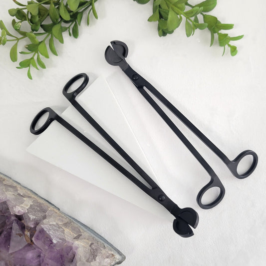 Matte black wick cutter styled as a decorative candle accessory. Sleek design pairs perfectly with intentional candle rituals.