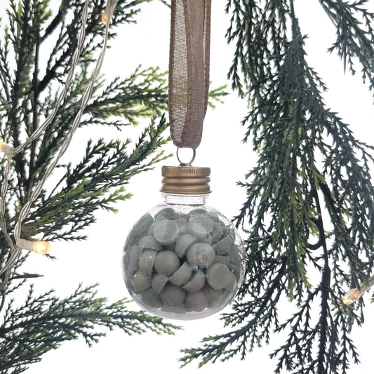 Winter + Wishes ornament filled with 2 oz of beaded coconut wax melts, hanging on a Christmas tree as a festive holiday decoration.